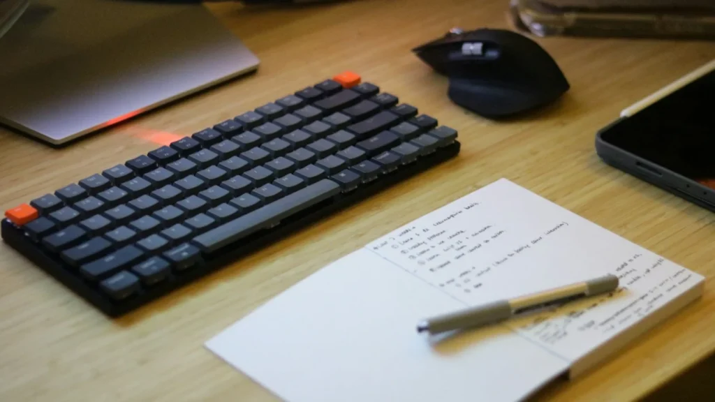 キーボードとメモ帳が置かれたデスク